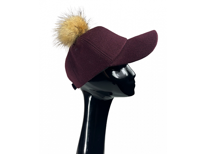 Bordo spalvos kepuraitė su snapeliu ir masyviu natūralaus kailio bumbulu